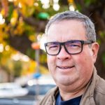 Smiling mature man looking at the camera at his home front yard